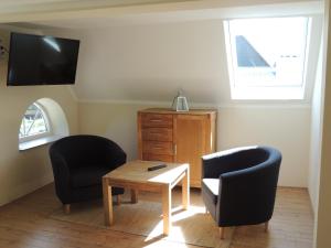 a living room with two chairs and a table at Lindenhof in Grömitz