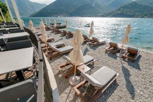 a group of lounge chairs and umbrellas on a beach at Apartments Simic in Kamenari