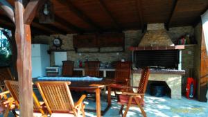 a kitchen with a table and chairs and a fireplace at ATHINA'S HOUSE in Nea Potidaea