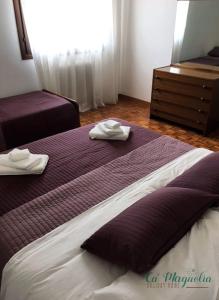 una camera d'albergo con due letti e asciugamani di Ca'Magnolia a Treviso