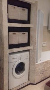 a washer and dryer in a bathroom with a wall at Villa Victoria in Gradac
