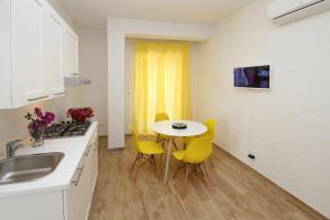 a kitchen with a small table and yellow chairs at villa aurora in Giardini Naxos