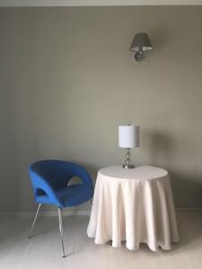 ジェロナ・グラにあるSANTOSA Pokoje Goscinneのテーブル、青い椅子、ランプ