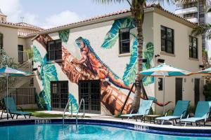 a mural on the side of a building next to a pool at Generator Miami in Miami Beach