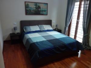 1 dormitorio con 1 cama con manta azul y blanca en B&B VILLA ROSA, en Bitritto
