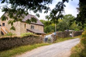 an old stone house on a dirt road at The Apple Loft in Ludlow