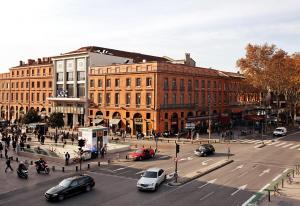 een drukke stadskruising met auto's in een drukke straat bij Citiz Hotel in Toulouse