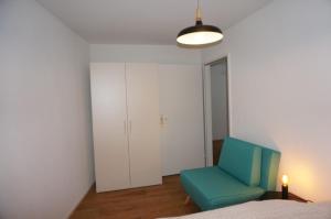 アローザにあるParadies 017のベッドルーム1室(ベッドの横に青い椅子付)