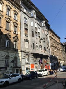 a large building with cars parked in front of it at PrimeQ CityCenter Apartments in Budapest