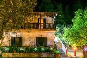 a building with a balcony and stairs in front at Spiros Rooms in Panormos Skopelos