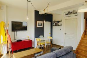 a living room with a couch and a table at Duplex Hermine Cosy, jardin sud & parking in Saint Malo