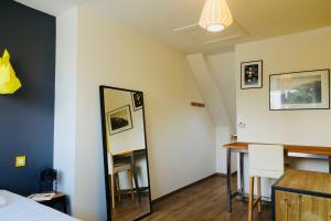 a room with a mirror and a table and a bed at Duplex Hermine Cosy, jardin sud & parking in Saint Malo