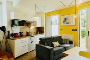 a living room with a couch and a kitchen at Duplex Hermine Cosy, jardin sud & parking in Saint Malo