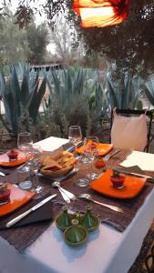 einen Tisch mit Gläsern und Teller mit Essen drauf in der Unterkunft Les Trois Paons in Taroudant