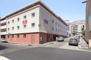 un edificio al lado de una calle con coches aparcados en Appart'City Confort Marseille Centre Prado Vélodrome, en Marsella
