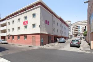 un bâtiment sur le côté d'une rue avec des voitures garées dans l'établissement Appart'City Confort Marseille Centre Prado Vélodrome, à Marseille