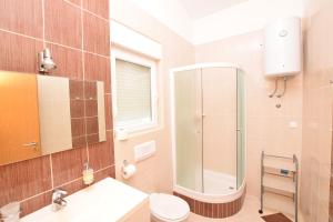un bagno con doccia, WC e lavandino di Apartment DIVA a Nin Altre 30 foto