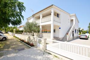 una casa bianca con una recinzione bianca di Apartment DIVA a Nin