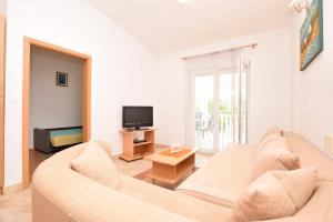 ein Wohnzimmer mit einem Sofa und einem TV in der Unterkunft Apartment DIVA in Nin