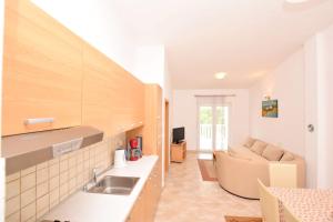 una cucina con lavandino e un divano in una camera di Apartment DIVA a Nin