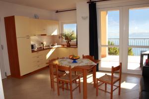 cocina y comedor con mesa y sillas en Residence Le Azalee & SPA, en Vercana