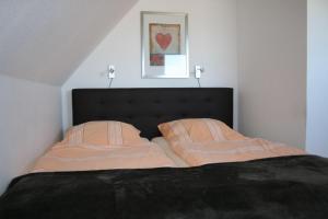 a bedroom with a bed with two pillows on it at Nickelshus-Whg-Lars in Sankt Peter-Ording
