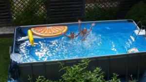 two people in a pool with a slice of orange at Ferienwohnungen Maurer in Umhausen
