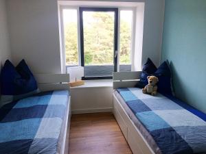 ein Schlafzimmer mit zwei Betten mit einem Teddybär dazwischen. in der Unterkunft Heimathafen Prora, 3.OG mit Meerblick in Binz