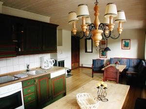 cocina con lámpara de araña y comedor en Hunderfossen Apartments en Hafjell