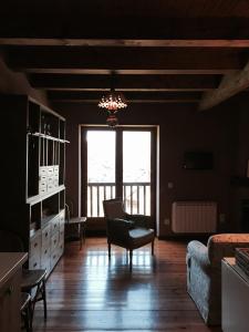 a living room with a large window and a chair at Apartamento vistas Taull in Taüll