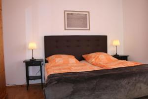 ein Schlafzimmer mit einem Bett mit zwei Lampen an Tischen in der Unterkunft Nickelshus Whg. Robin in Sankt Peter-Ording