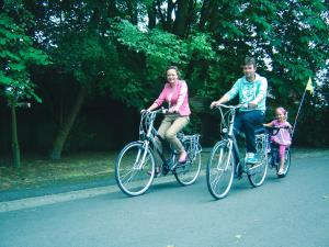 a man and a woman riding bikes with a child at B&B Wisteria in Herne