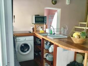 une cuisine avec un lave-linge et un micro-ondes dans l'établissement bienvenue à bord, à Saint-François