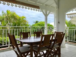 une table et des chaises en bois sur un porche dans l'établissement bienvenue à bord, à Saint-François