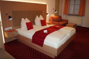 um quarto de hotel com uma cama grande e uma cadeira em Hotel Traube em Sigmaringen