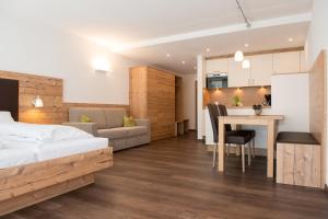 a bedroom with a bed and a kitchen and a table at Ferienpark Tulai - Fam. Carl in Scuol