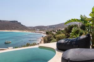 a swimming pool on the side of a beach at Panormos Village Hotel in Mykonos