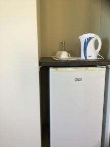 a white refrigerator with a counter on top of it at Pearl Oyster guesthouse in St Francis Bay