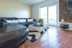 a living room with a leather couch and a table at Luxury apartment Antonija-old town in Cavtat