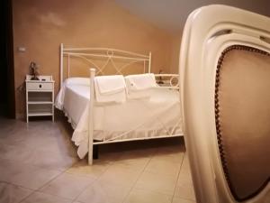 a bedroom with a white bed with white pillows at La Rosa Del Barone in Cancellara