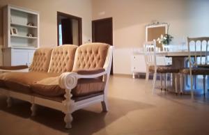 sala de estar con sofá, mesa y sillas en La Rosa Del Barone en Cancellara