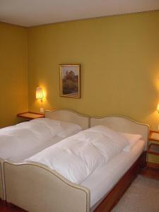 1 cama blanca en una habitación con 2 lámparas en Gasthof Bären Laupen, en Laupen