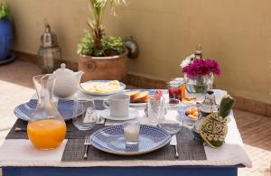 a table with plates of food and orange juice at Riad Villa Harmonie in Marrakech