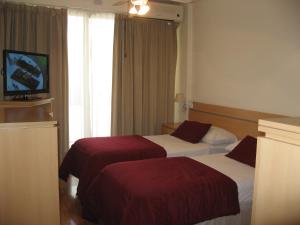 a hotel room with two beds and a television at Apart San Diego Recoleta in Buenos Aires