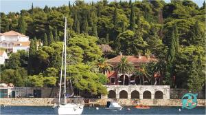 a boat in the water in front of a house at Luxury apartment Antonija-old town in Cavtat