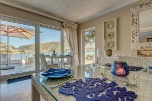 ein Esszimmer mit einem Glastisch und Meerblick in der Unterkunft Amanzi Island Boutique Hotel in Knysna