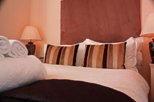 a bed with a white comforter and pillows at Annandale Arms Hotel in Moffat