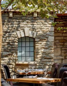 a wooden table with wine glasses in front of a stone wall at Best Western Compass Inn in Tormarton +28 photos