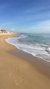 plaża ze śladami stóp na piasku i oceanem w obiekcie Apartamento Playa Guardamar del Segura w mieście Guardamar del Segura