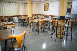 a restaurant with tables and chairs in a room at Hotel Graunas in São Carlos